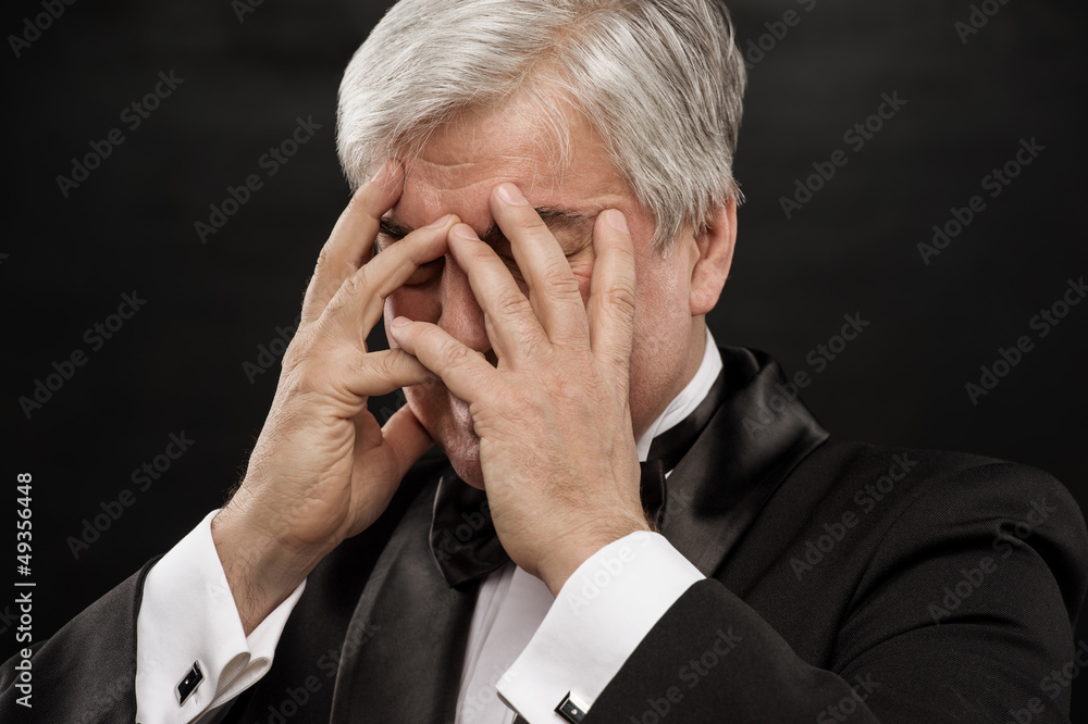 Portrait of a mature business man looking depressed from work ov Portrait of a mature business man looking depressed from work ov