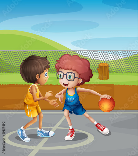 Two boys playing basketball at the court