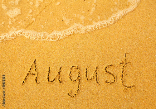 August - written in sand on beach texture © De Visu