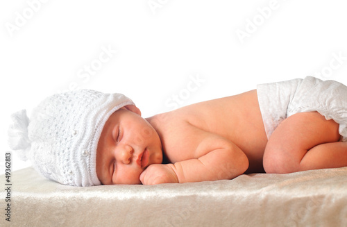 sleeping newborn baby girl in white hat wearing diaper