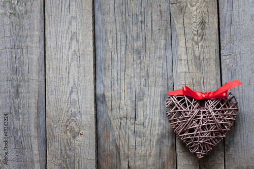 Wicker heart on vintage boards love background concept