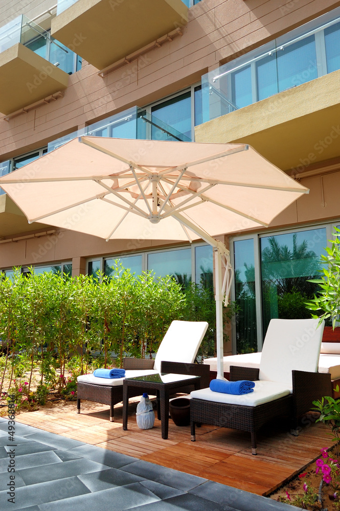 Fototapeta premium Leżaki i parasol w pobliżu budynku luksusowego hotelu, Dubaj, Zjednoczone Emiraty Arabskie