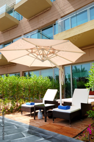 Sunbeds and umbrella near building of luxury hotel, Dubai, UAE