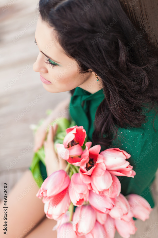 Beautiful young brunette woman with pink tulips Beautiful young brunette woman with pink tulips