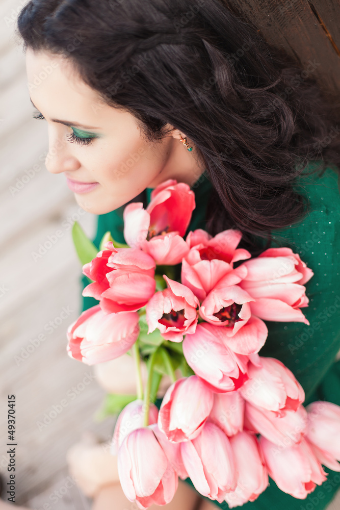 Beautiful young brunette woman with pink tulips Beautiful young brunette woman with pink tulips