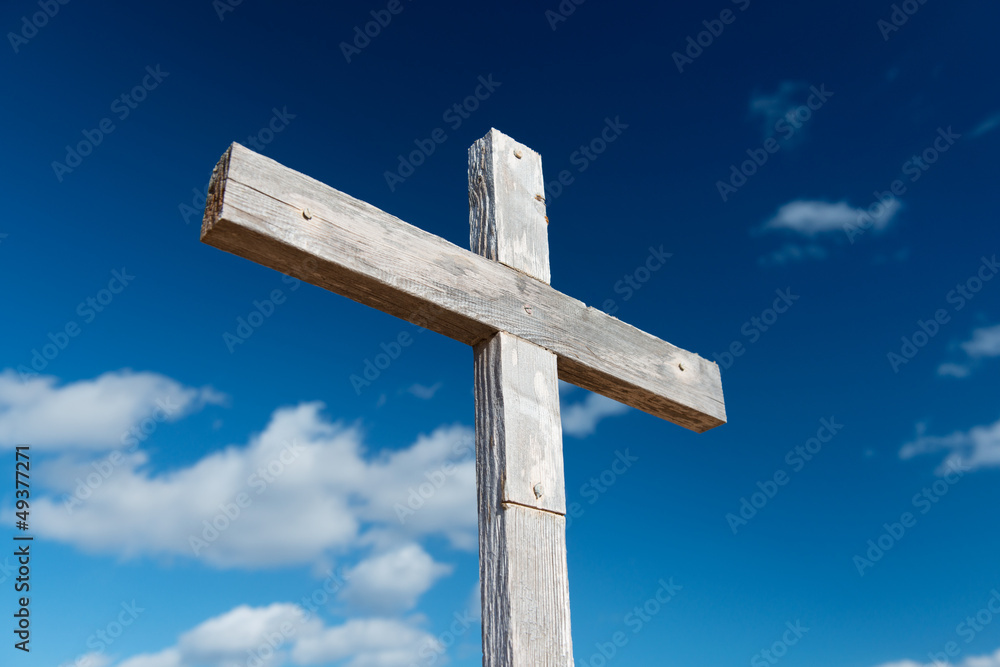 holzkreuz vor blauem himmel