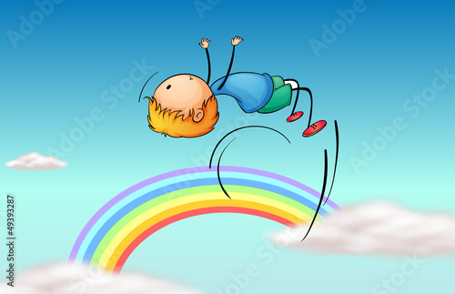 A boy jumping in the sky and a rainbow