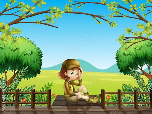 A girl sitting at the wooden bridge