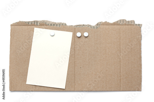Piece of cardboard with pins and note