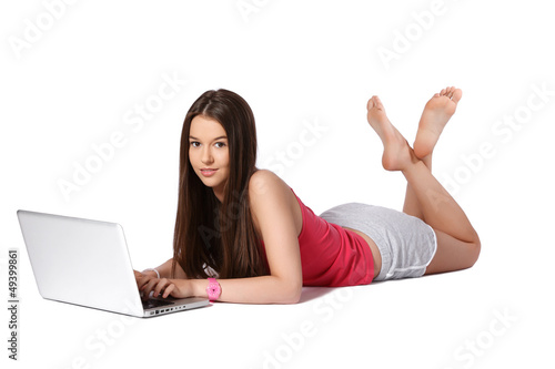 young female student casually lying on the floor with a laptop