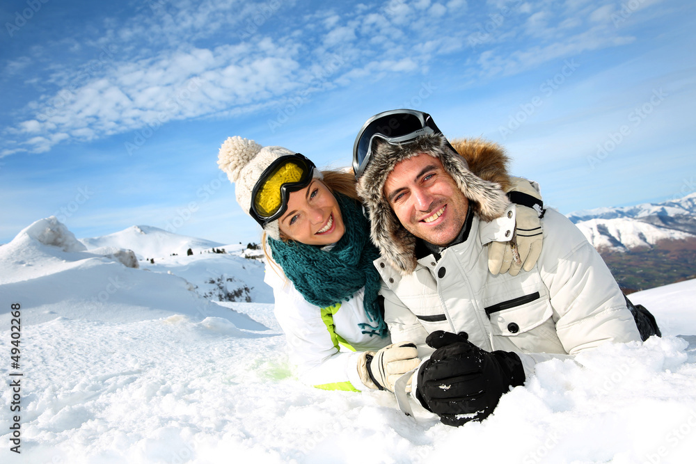 Couple of skiers laying down in the snow Couple of skiers laying down in the snow
