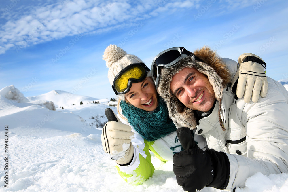 Couple of skiers laying down in the snow Couple of skiers laying down in the snow