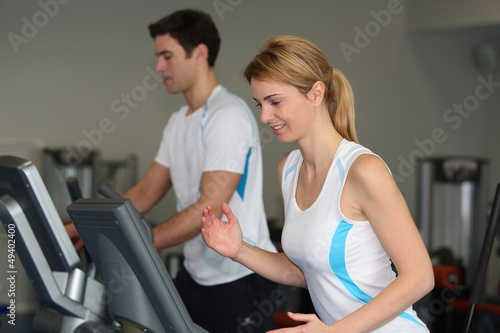 Couple in fitness gym using running belt