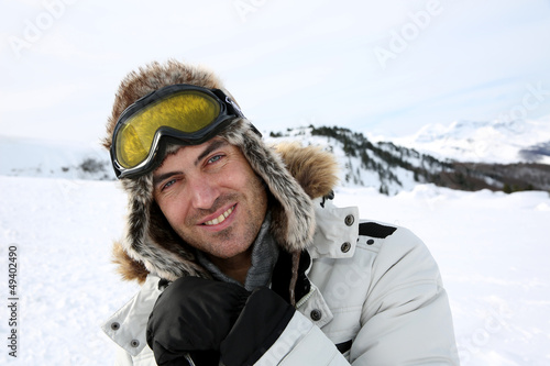 Portrait of swnowboarder standing on snow track
