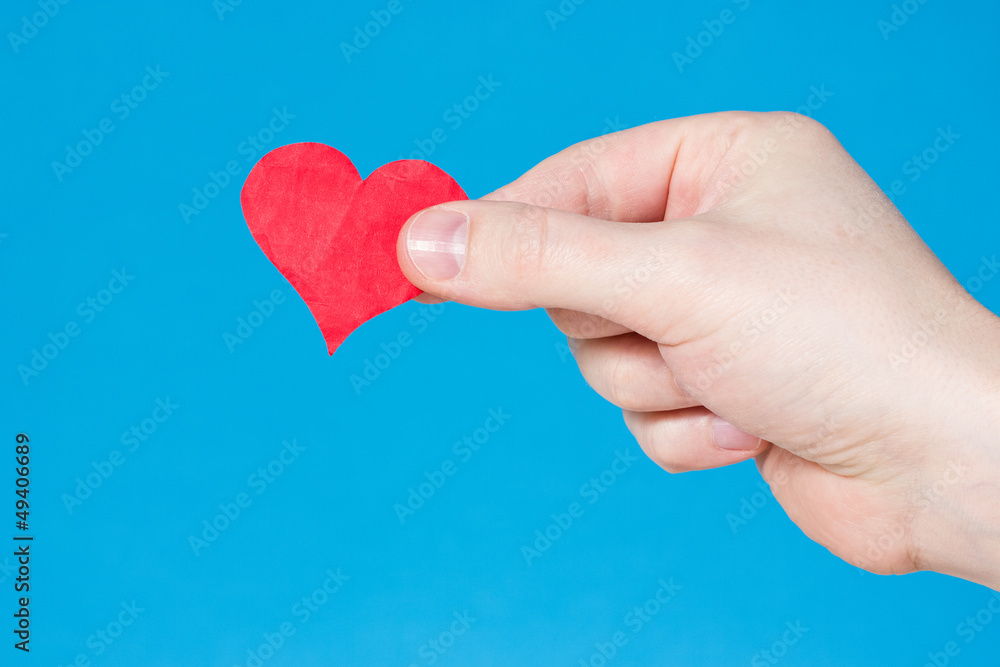 Fototapeta premium Hand with heart on blue background