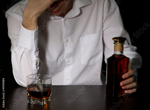 Man with bottle of alcohol, on black background