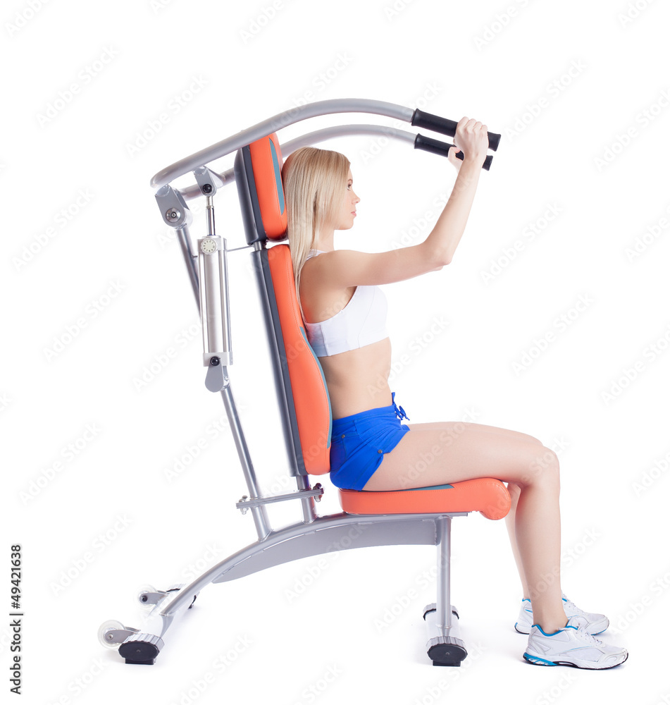 Young woman sitting on orange hydraulic exerciser Young woman sitting on orange hydraulic exerciser