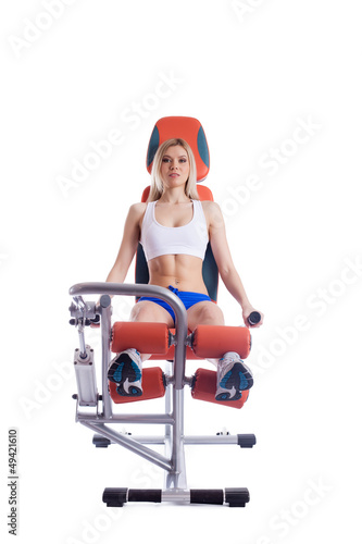 Blonde woman sitting on orange hydraulic exerciser photo