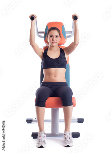 Brunette woman sitting on hydraulic exerciser photo