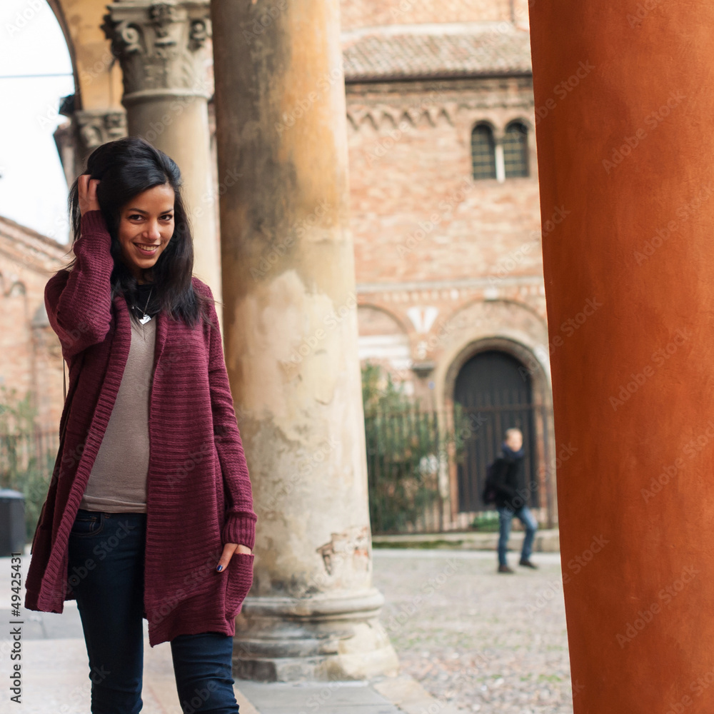 Young woman walking outdoors in s. Stephen, Bologna, Italy.