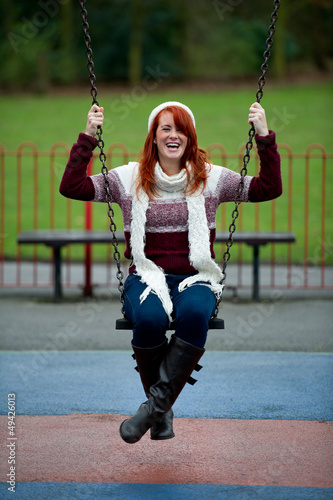Pretty young female having fun on swing