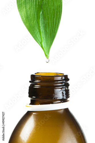 Fototapeta Naklejka Na Ścianę i Meble -  Green leaf and drop over a tube of cosmetics