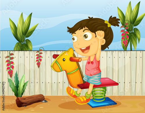 A little girl playing inside the fence