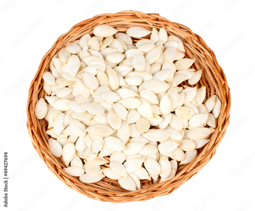 Pumpkin seeds on wicker mat, isolated on the white Pumpkin seeds on wicker mat, isolated on the white