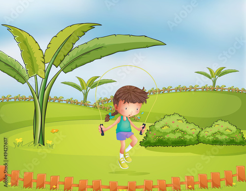 A girl playing jumping rope in the park