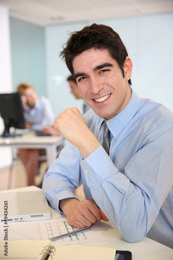 Cheerful salesman working on laptop computer Cheerful salesman working on laptop computer