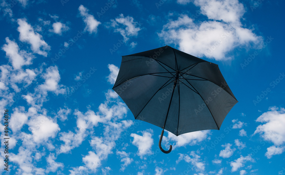 Black umbrella against a cloudy sky
