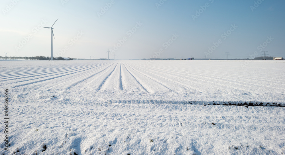 Wind turbine in a snowy field in sunlight Wind turbine in a snowy field in sunlight