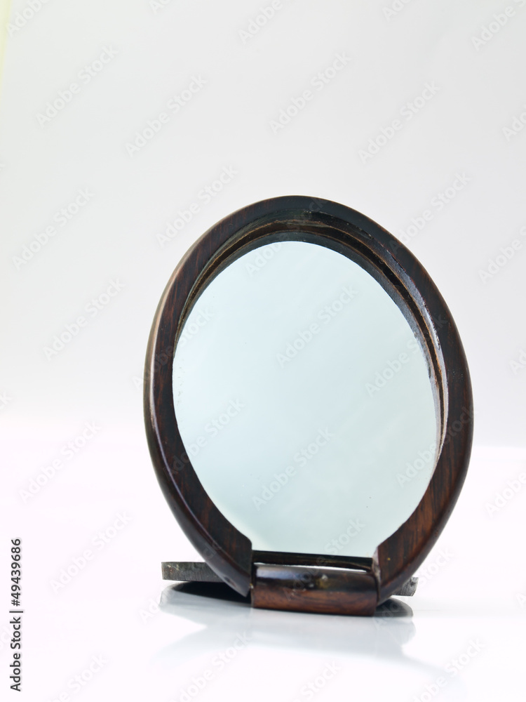 A wooden pocket makeup mirror isolated on white background A wooden pocket makeup mirror isolated on white background