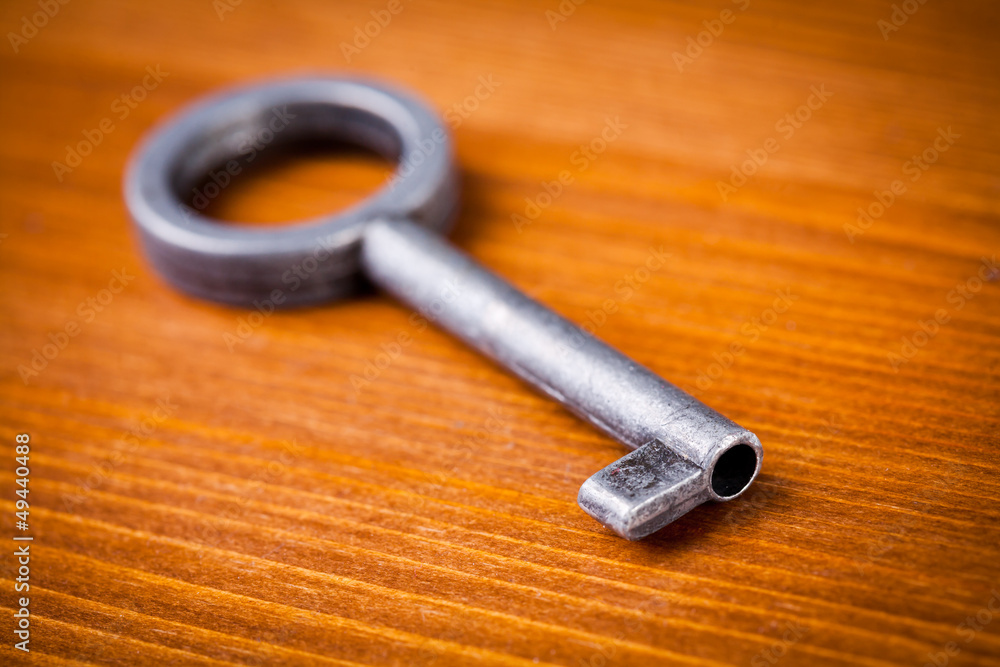 Old key on wooden table, close up photo Old key on wooden table, close up photo
