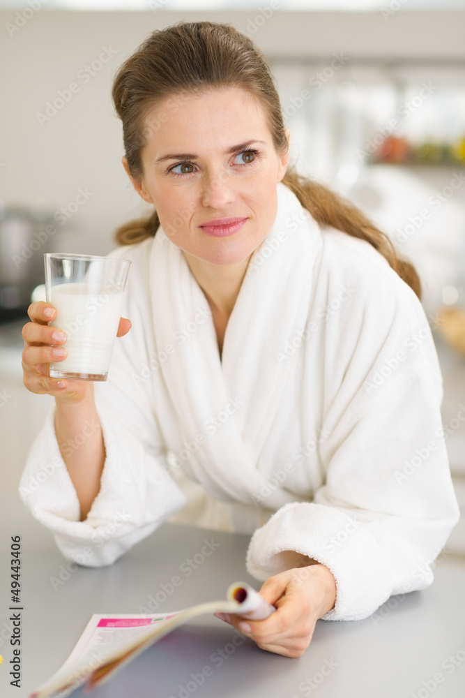 Young woman in bathrobe with milk and magazine Young woman in bathrobe with milk and magazine