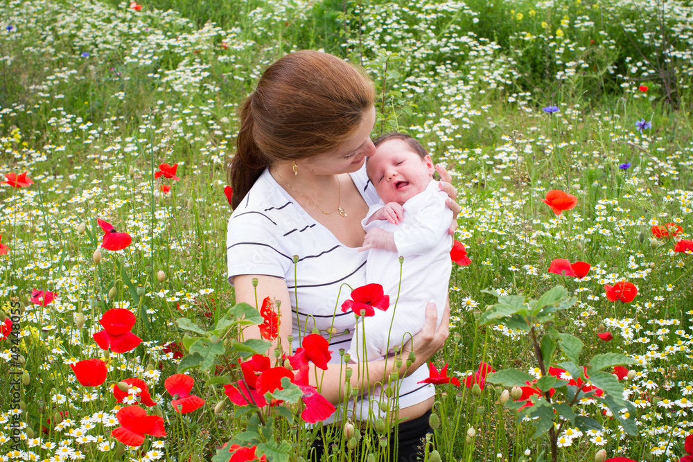 Mother and her newborn baby in a beautiful flower field Mother and her newborn baby in a beautiful flower field