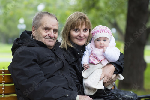 Great-grandfather, grandmother and baby girl on a bench