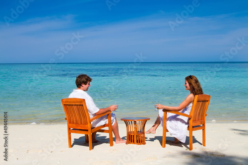 Young beautiful couple enjoying cocktails on a tropical beach © famveldman