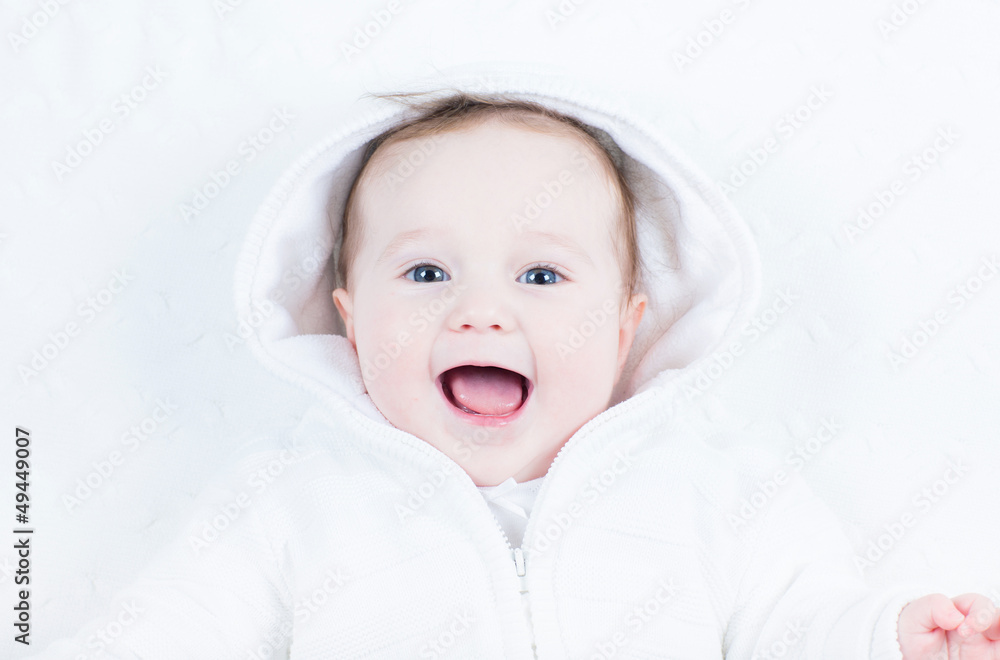 Laughing happy baby in a white knitted jacket Laughing happy baby in a white knitted jacket
