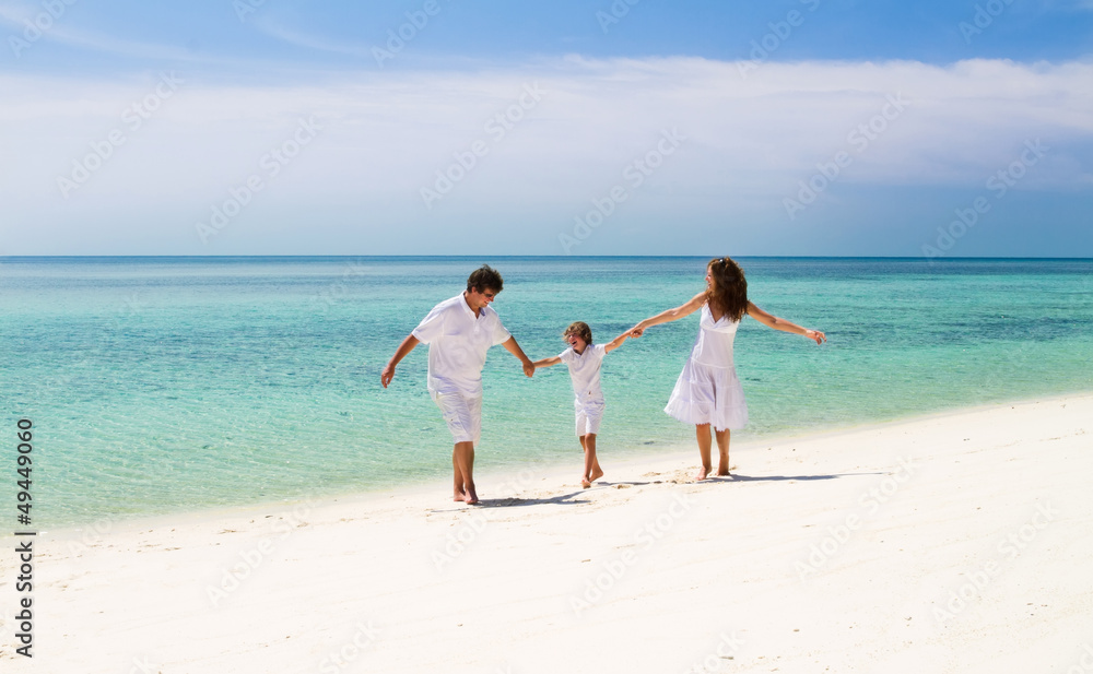 Beautiful family of three dancing on a tropical beach