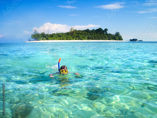 Little boy snorkeling next to a beautiful tropical island © famveldman