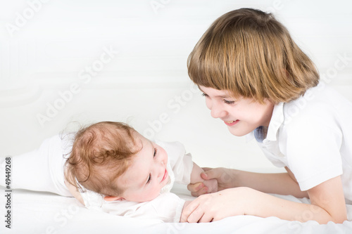 Adorable little baby girl playing with her big brother