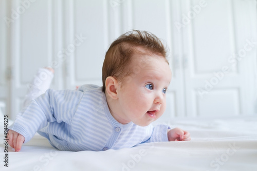 Baby tummy time in a white nursery