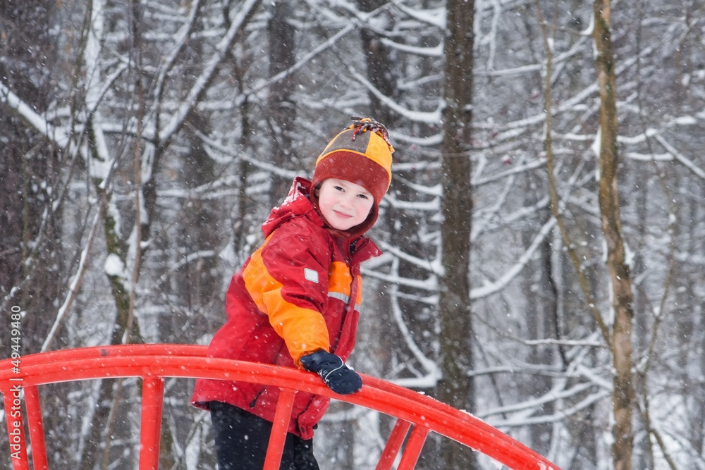Cute child playing in a snowy park
