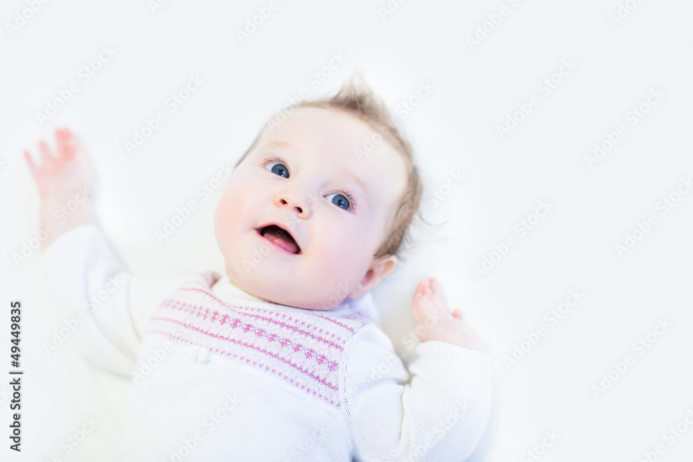 Curious baby girl in a white knitted dress Curious baby girl in a white knitted dress
