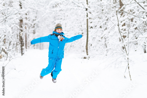 Funny boy jumping in a snowy park