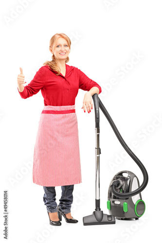 Obraz na płótnie Blond housewife posing on a vacuum cleaner and giving thumb up