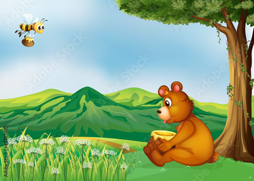 A bear sitting near a tree