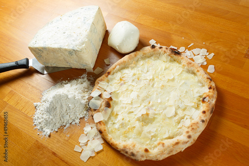 Italian Pizza, ingredients in the background on a wood table