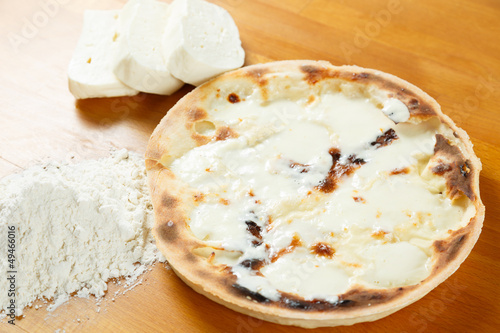 Foto Italian Pizza, ingredients in the background on a wood table